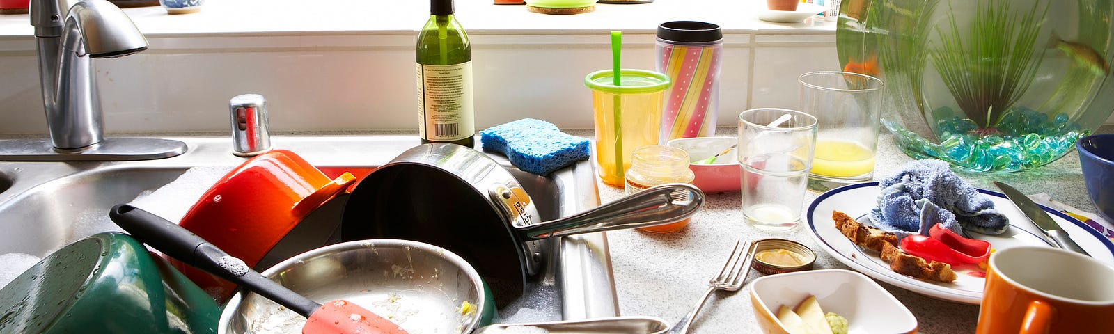 Cluttered kitchen sink with dirty dishes.