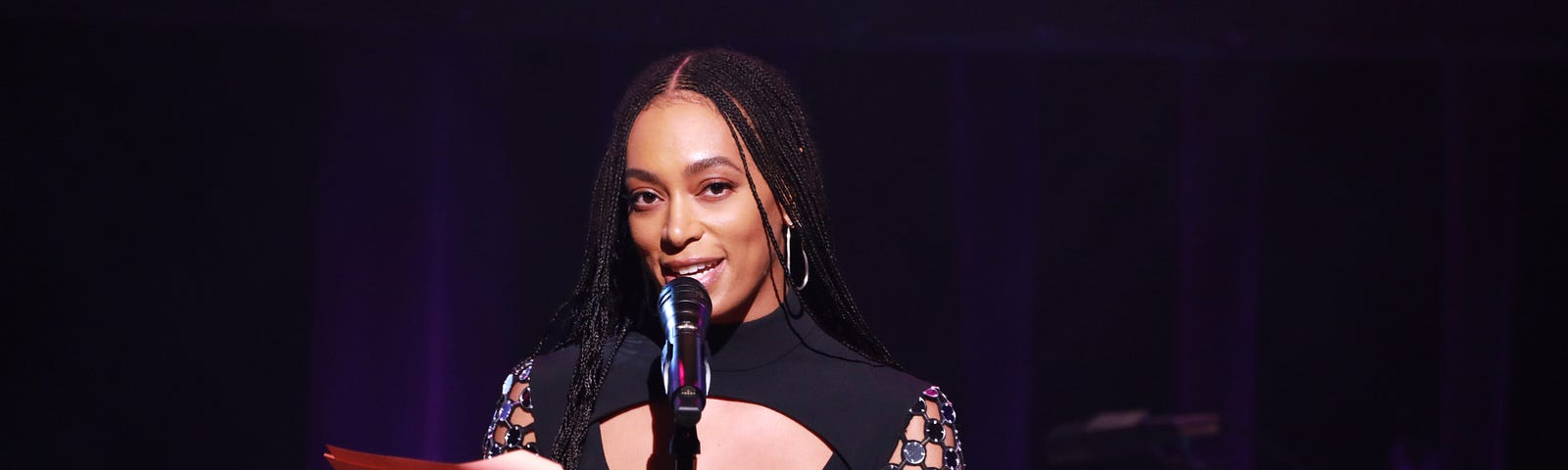 Solange accepting an award at an event.