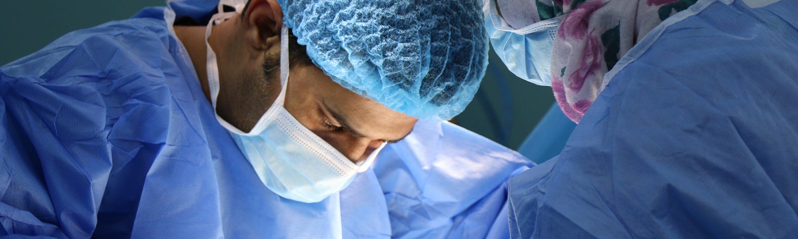 A doctor looks down as he prepares to start an operation.