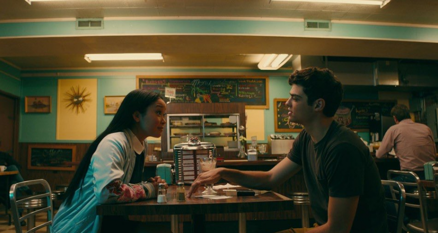 A photo still from the Netflix movie “To All the Boys I’ve Loved Before” that shows Lara Jean and Peter at a diner.