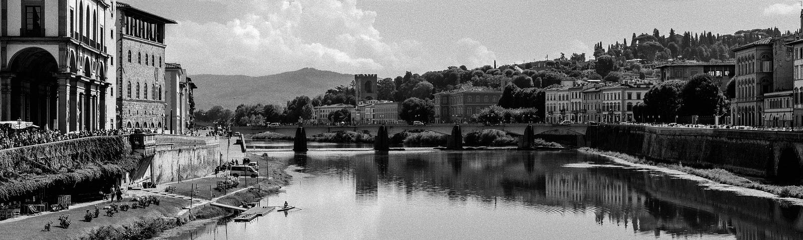 A black and white photo of the Arno River in Florence.