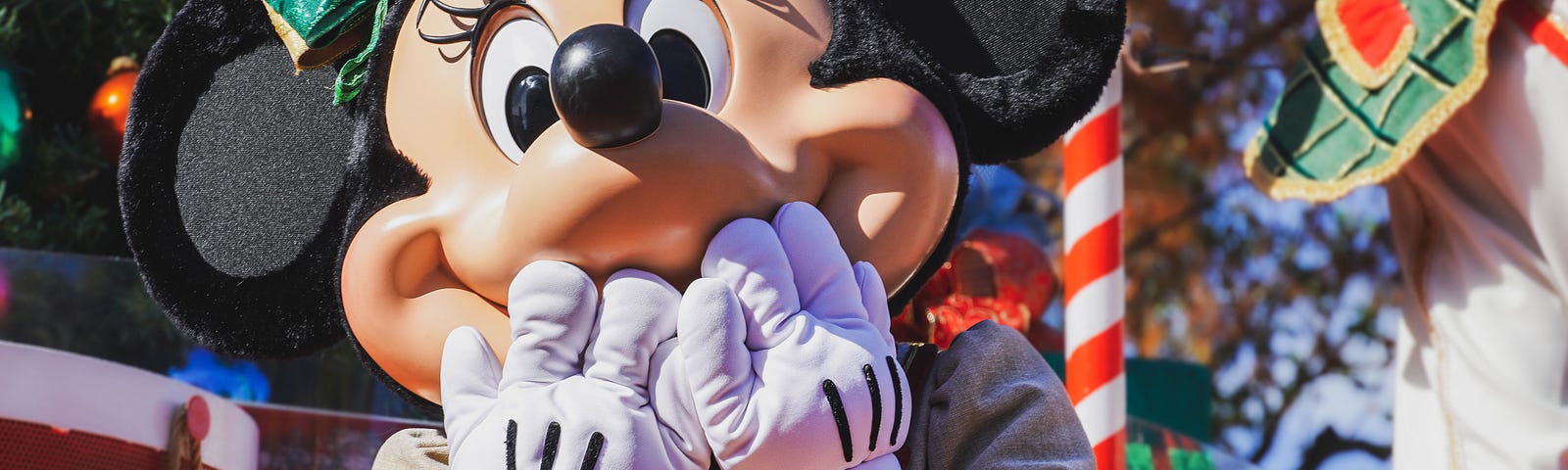 Photo of Disney character Minnie Mouse with eyes wide open and hands to her face as if in disbelief.