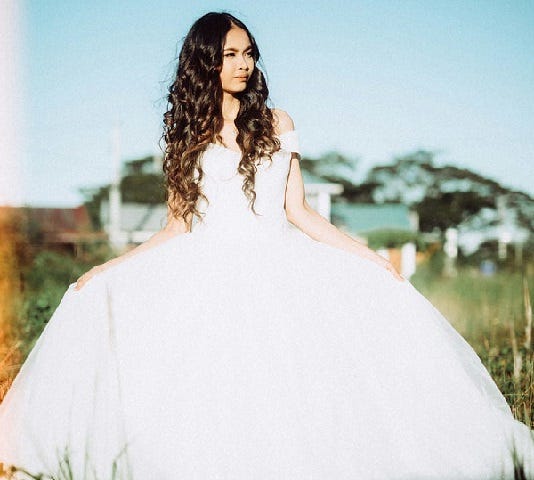 Young girl wearing large ball gown.