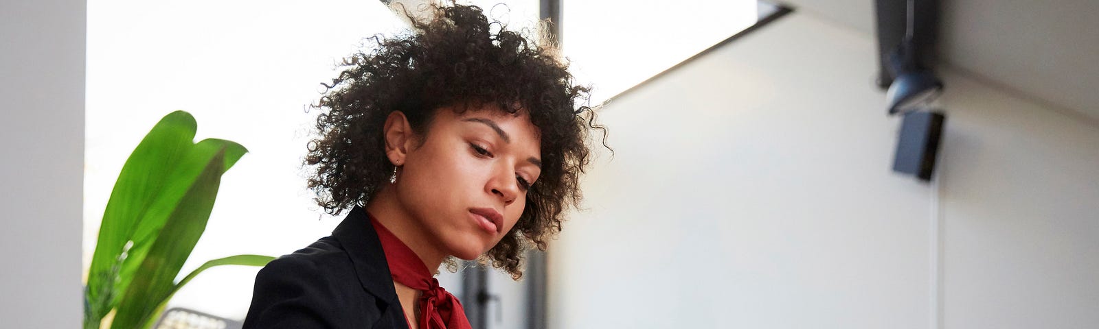 Confident Black woman writing down invoice at her computer.