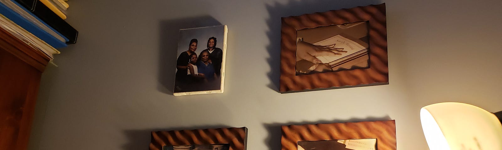 Family portraits hanging on the wall with dim lighting.