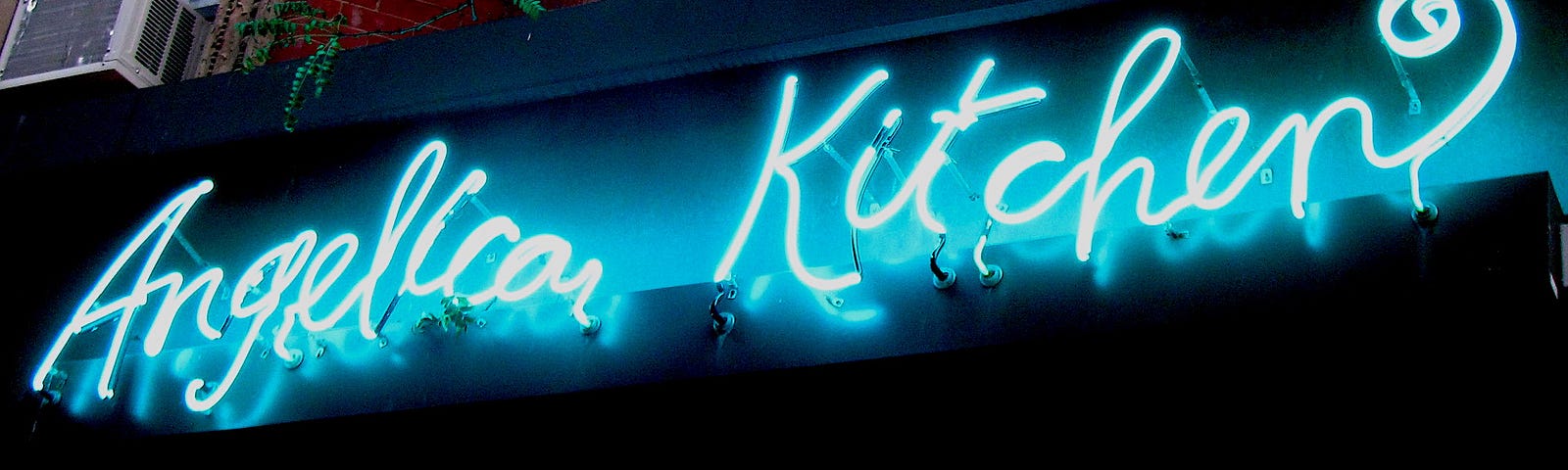 A blue neon sign reading Angelica Kitchen