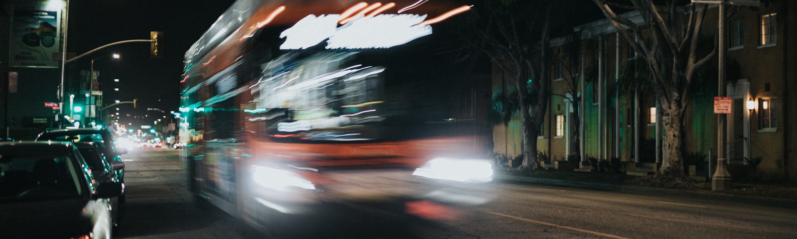 Blurred photograph of a bus moving at night.