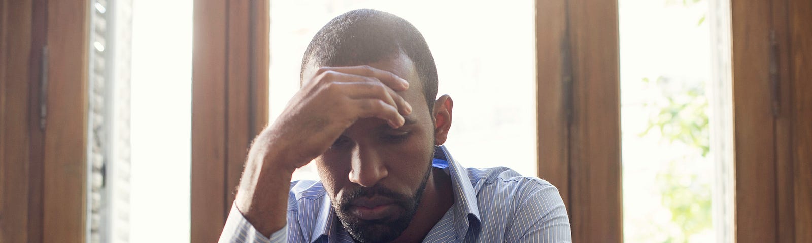 A man stares at his cell phone with a look of disappointment.