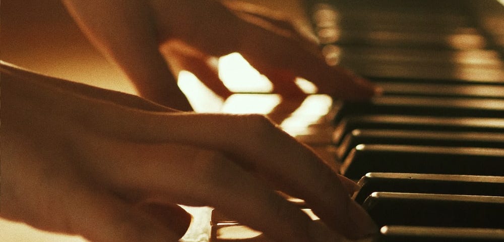 Female hands playing a piano.