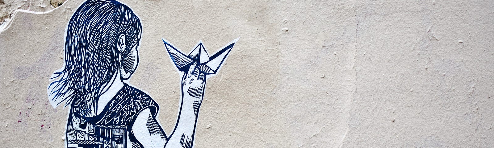 Graffiti made to look like pencil drawing of a girl holding paper origami. Her back is to the viewer.