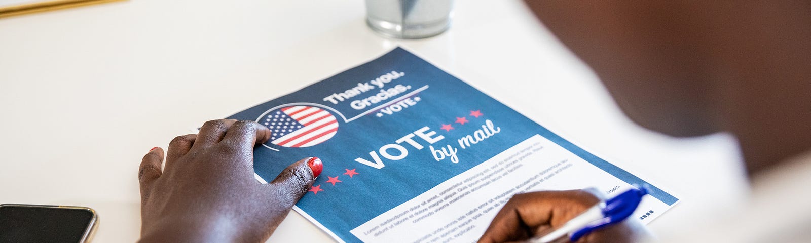 Young Black woman filling out a paper ballot to vote by mail.