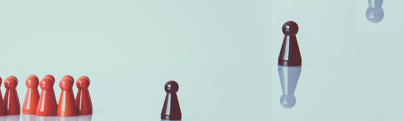 Chess pieces with three black ones illuminated with a reflection.