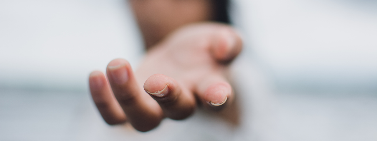 Blurry photo of girl holding out hand for An FBI Body Language Trick To Build Trust