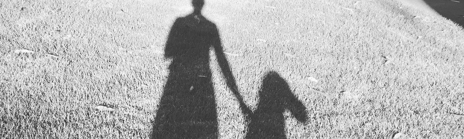 A black and white photo of the author’s shadow along with her dog’s shadow.