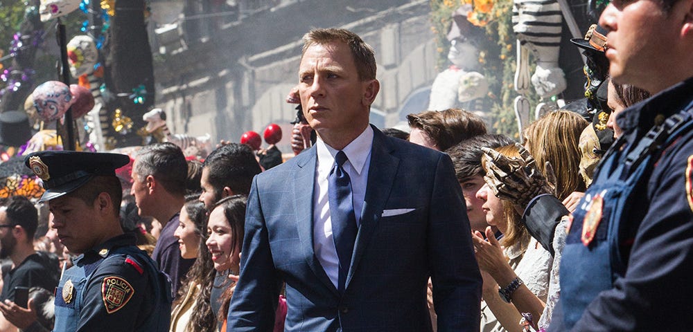 Daniel Craig as James Bond walks through a crowd from the movie set of 007: Spectre.