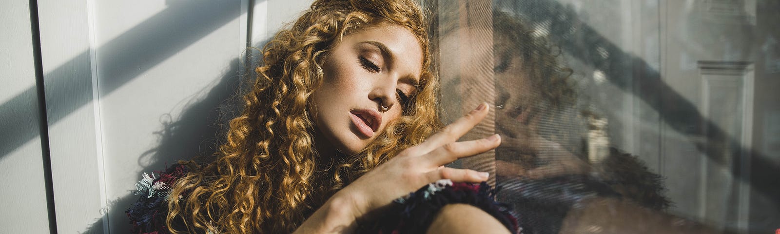 woman seating by glass wall in deep reflection