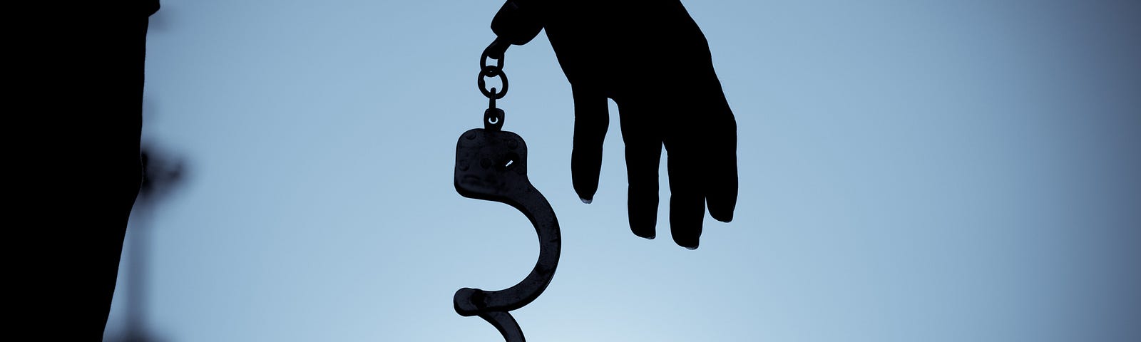 A photo of handcuffs being uncuffed on a person’s hand.