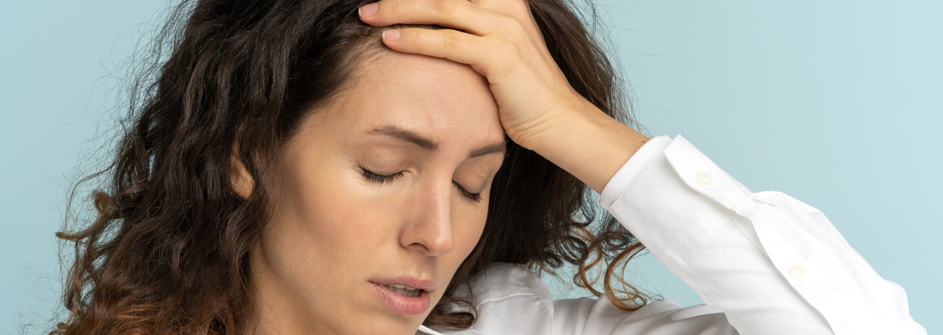 A woman facepalms and closes her eyes, a defeated expression on her face.