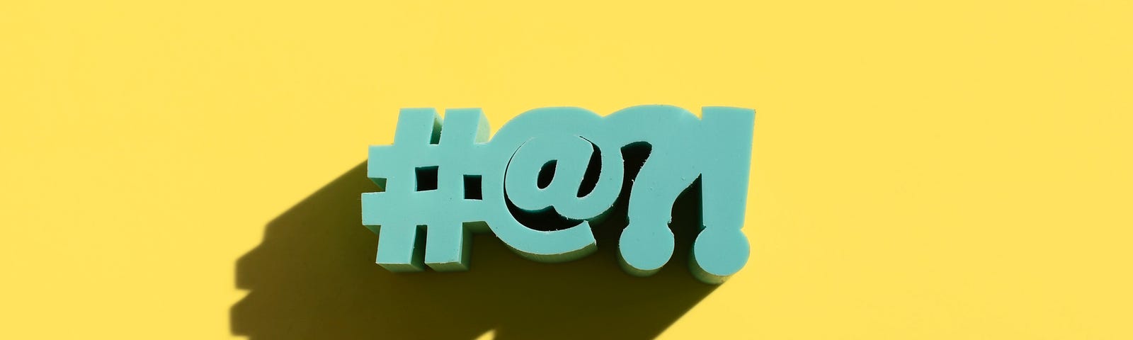 #@?! in block letters against a yellow background.