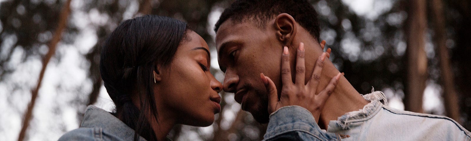 A photo of a black couple about to kiss.