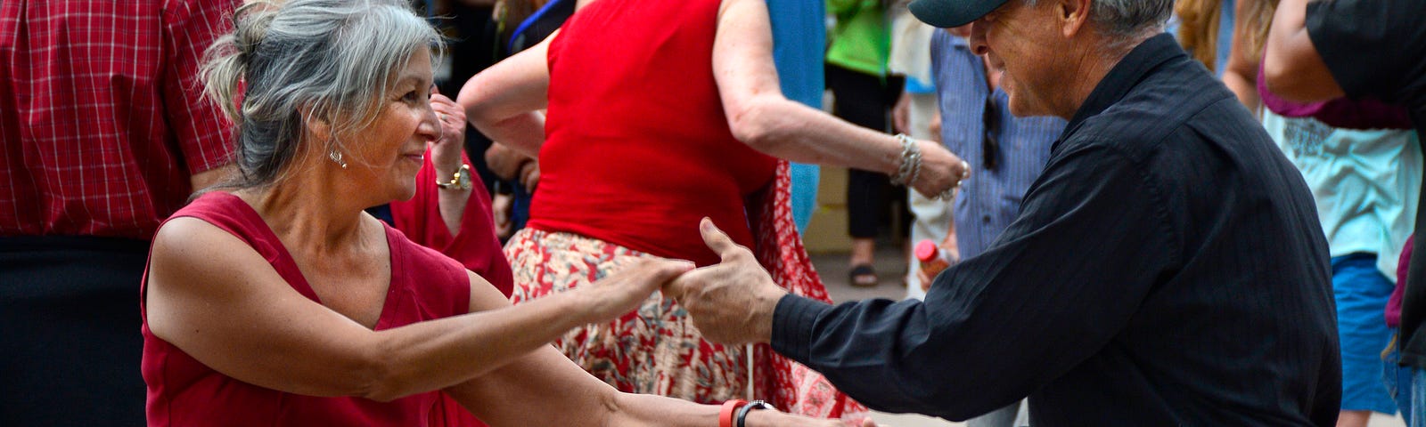 An older couple dances together at a party.