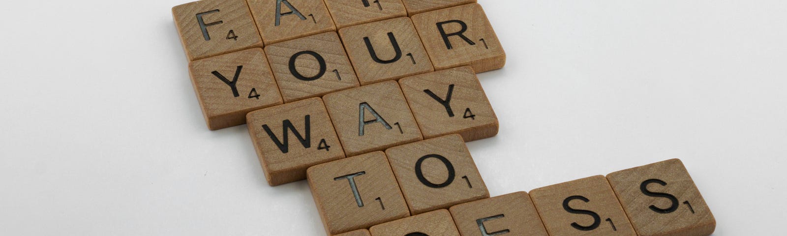 Scrabble tiles spelling out “Fail your way to success”