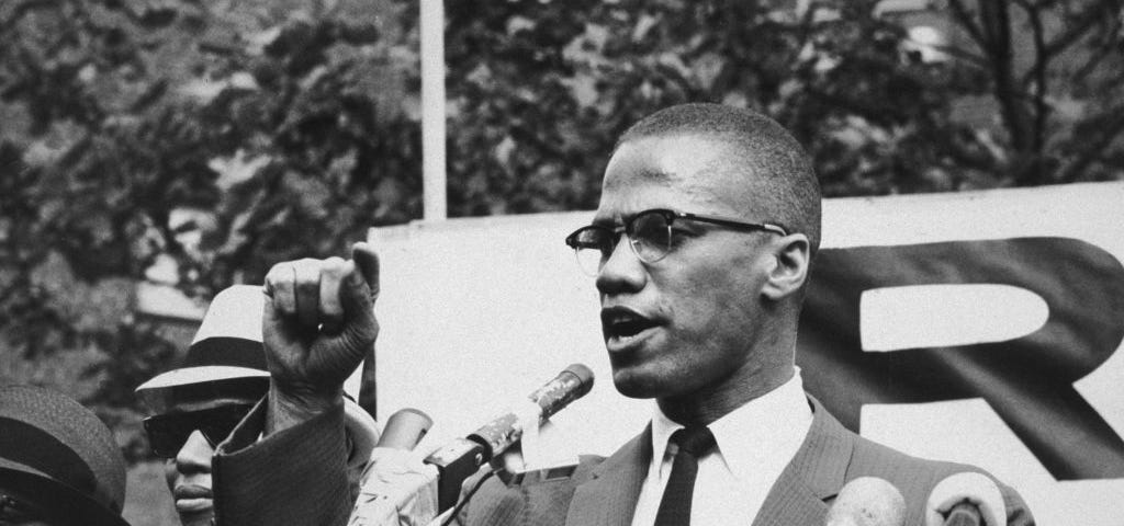 Malcolm X giving a speech at a rally.