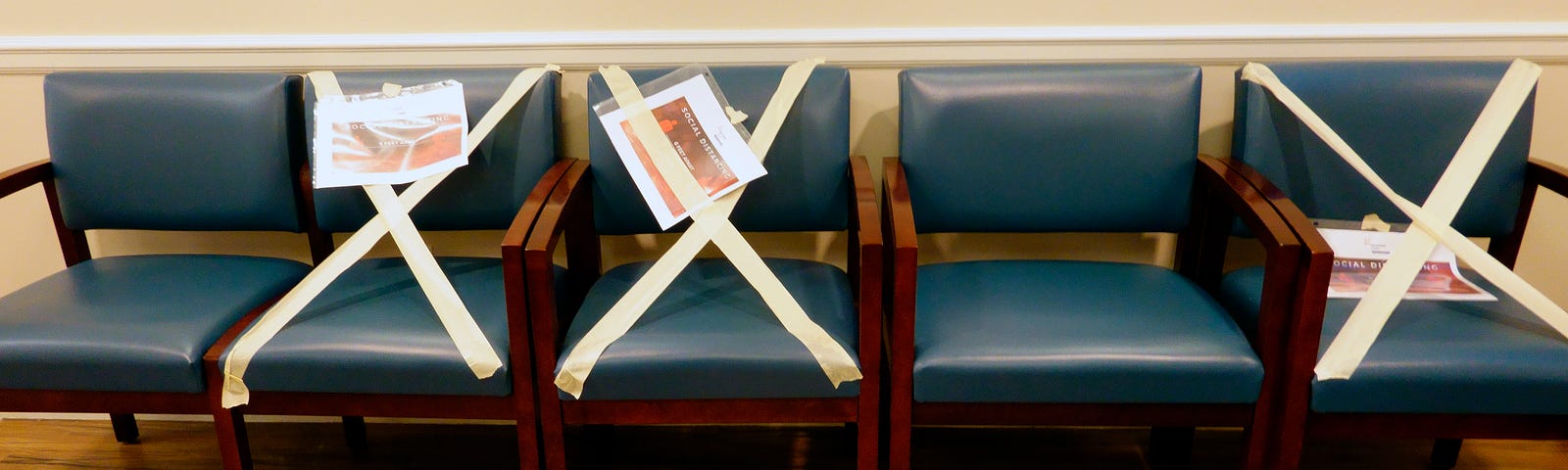 Chairs taped off in a waiting area.