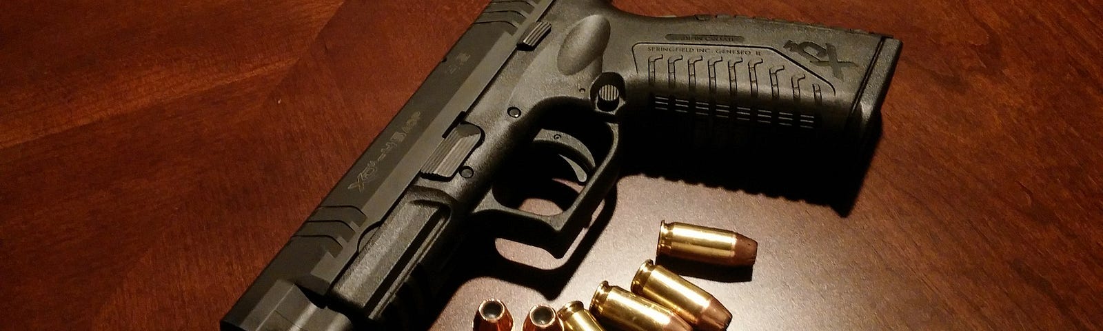 Handgun on wooden table with 7 bullets.