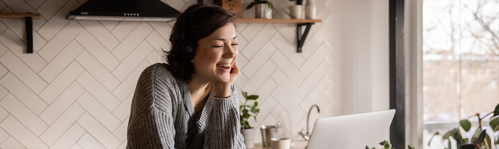 Smiling woman looking at laptop in kitchen