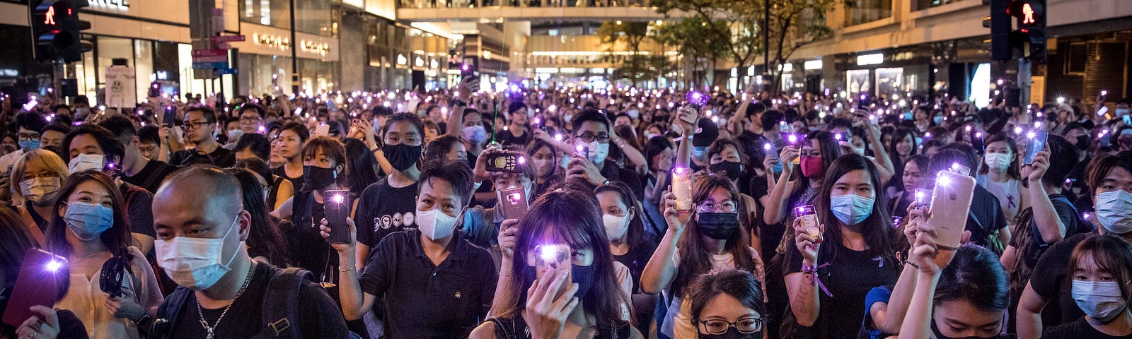 Protesters wave their phones in the air during a rally against police sexual harassment on August 28, 2019, in Hong Kong.
