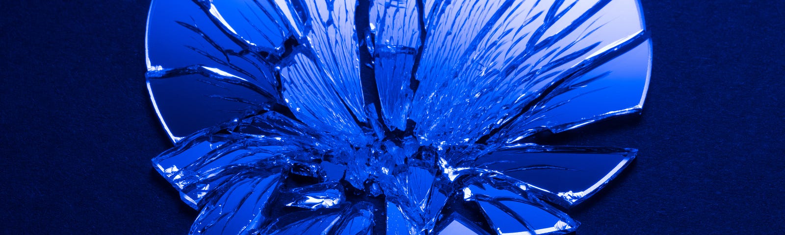 A blue-tinted photo of a shattered mirror.