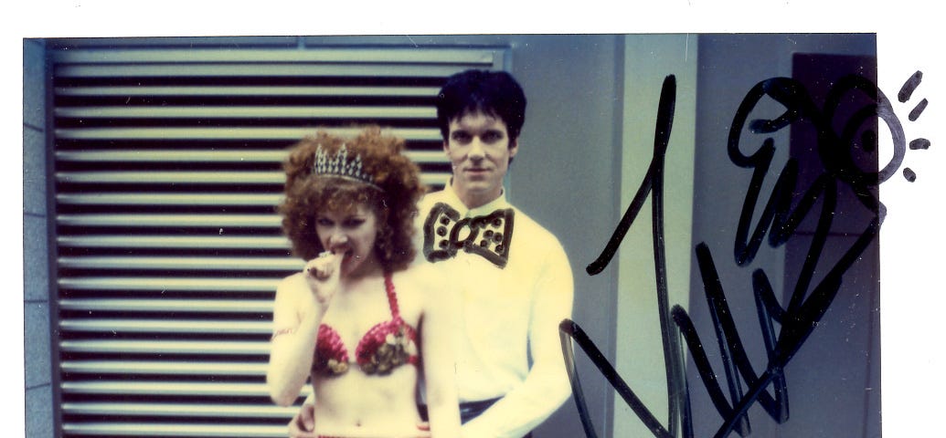 Signed polaroid of The Cramps on city street, dressed to kill.