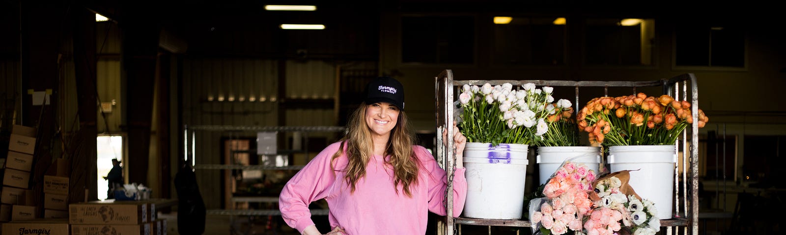 Christina Stembel stands next to various flowers in their warehouse.