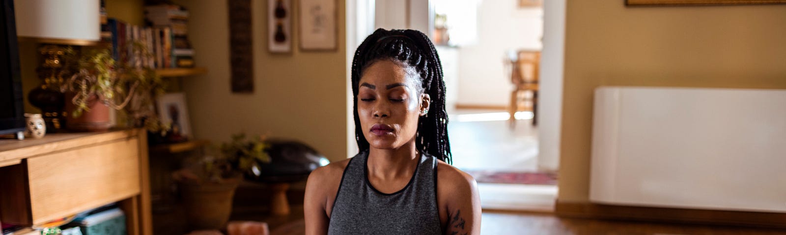 Close up of a young woman meditating at home.