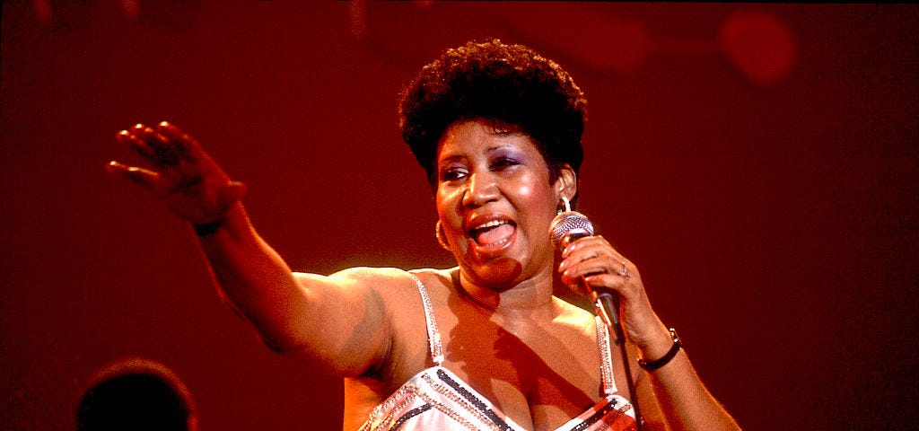 Aretha Franklin performing on stage.