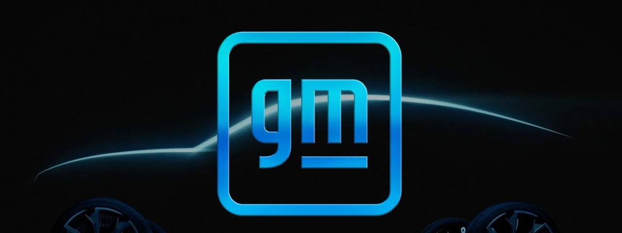 The new General Motors logo in front of a silhouette of a car.