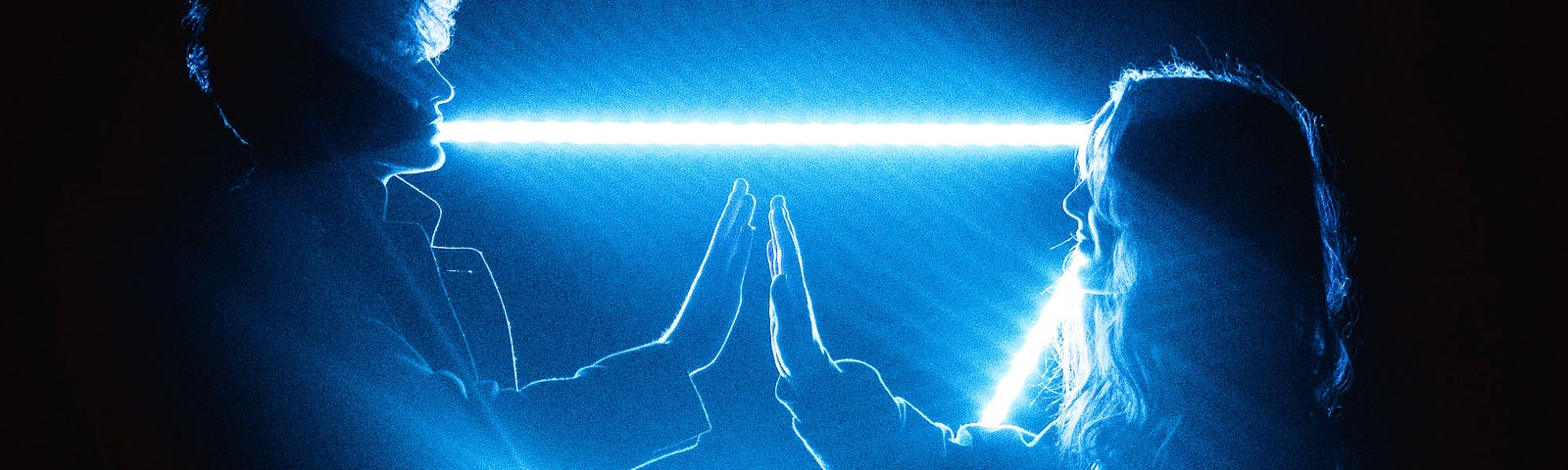 Couple joining hands against a triangle of blue light.