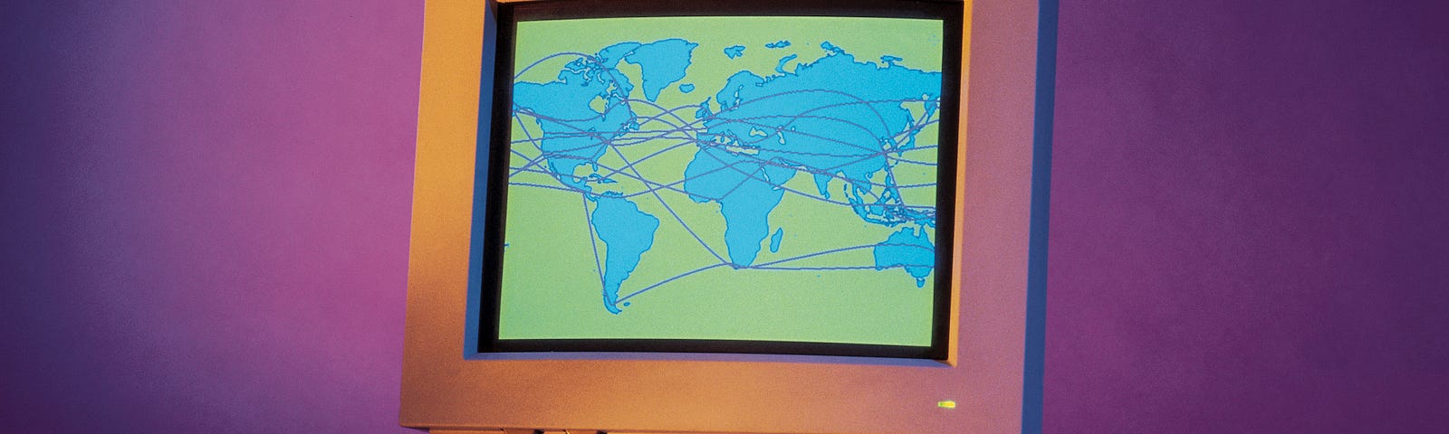 A photo of a retro desktop computer displaying a map of the world with a ton of lines connecting different parts.