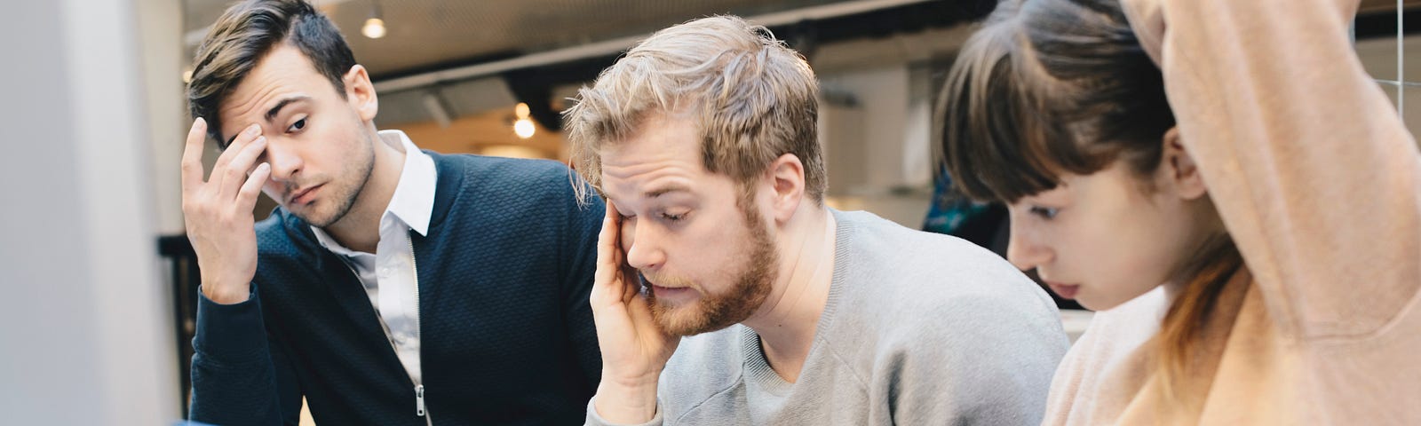 Stressed computer programmers looking at their computers in the office.