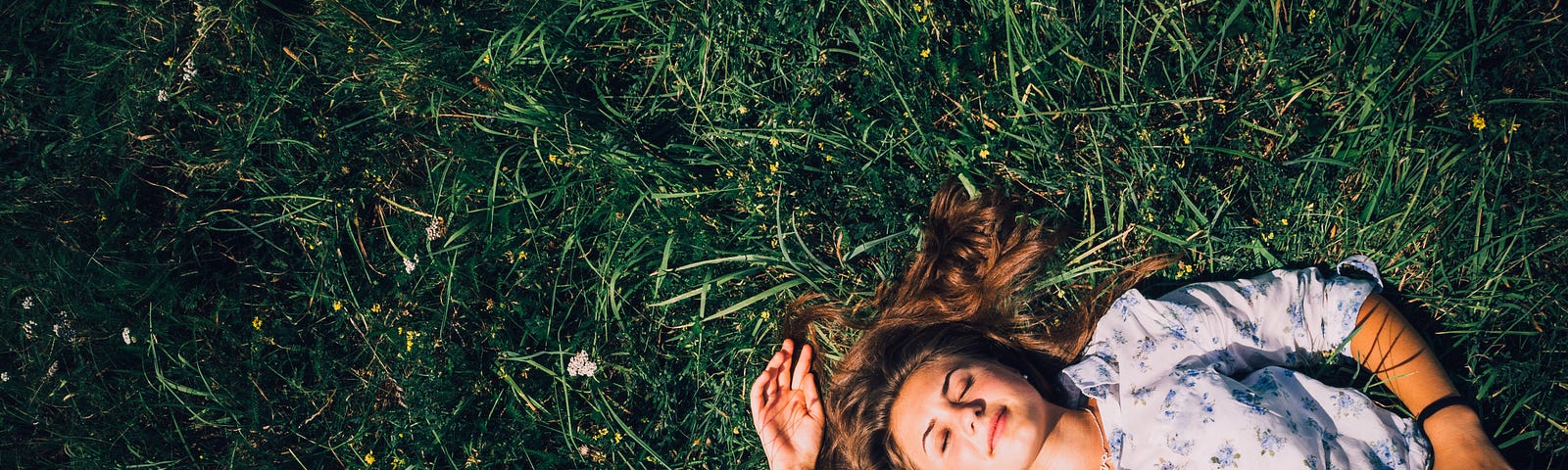 Woman lying on the grass in the sunshine