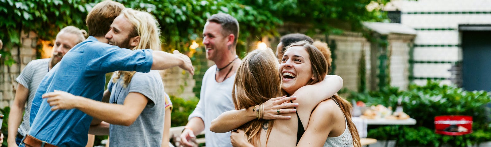 Group of friends hugging in person, no face masks.