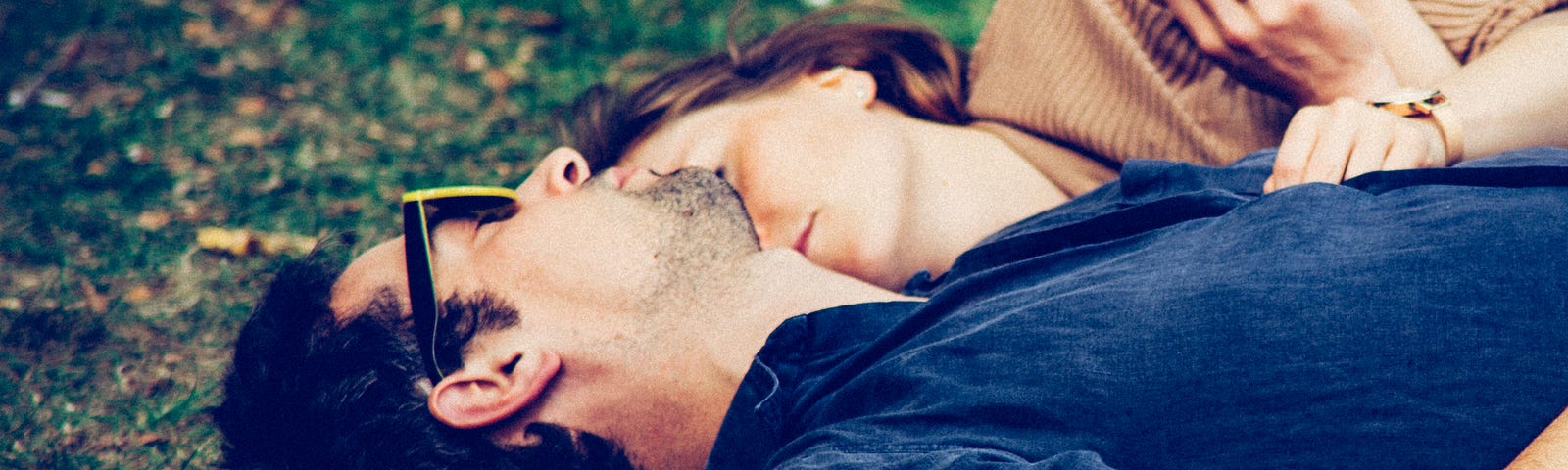 Two people cuddle on the grass together, eyes closed. #relationships #date #dating #love #cuddle #cuddling