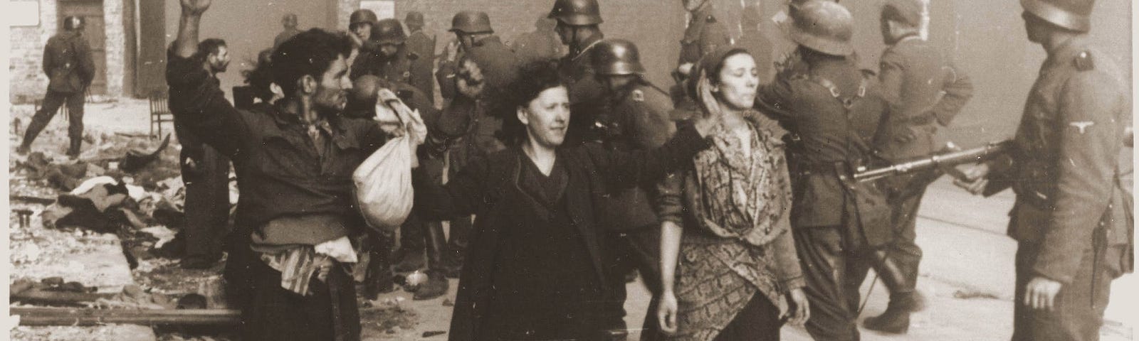 Nazi SS troops guarding members of the Jewish resistance captured during the Warsaw ghetto uprising in 1943.