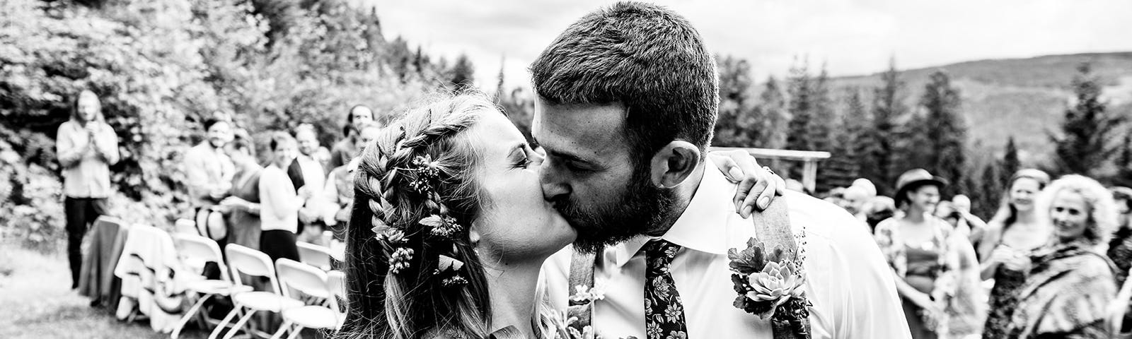 A black and white photo of the author kissing her husband on their wedding day.