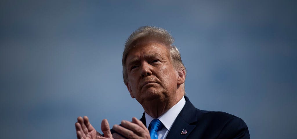 Trump clapping at a rally.