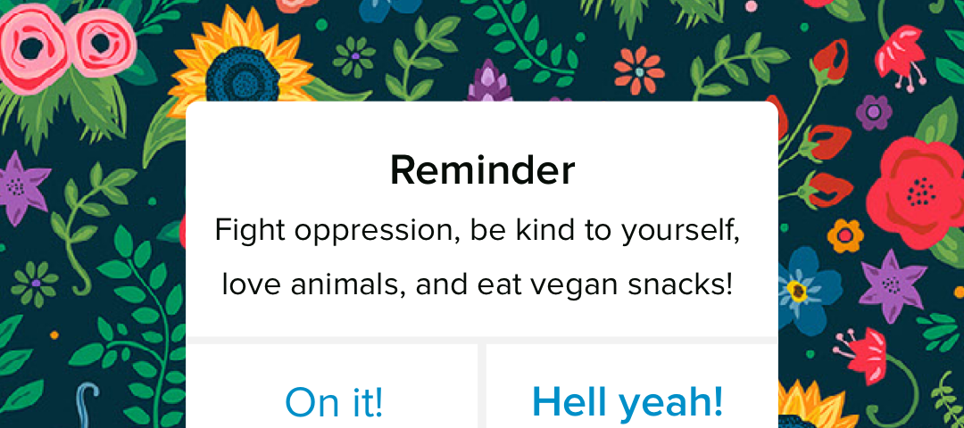 A phone notification on a floral bg: “Reminder: Fight oppression, be kind to yourself, love animals, and eat vegan snacks!”