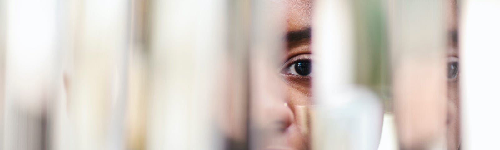 Portrait of a Black person reflected on multiple mirrors.