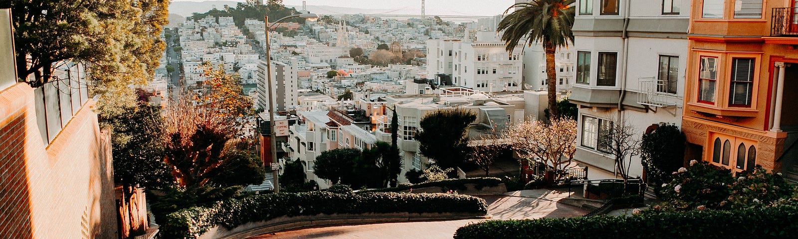 View of the city with Lombard Street in the foreground, as seen from the top of the hill Lombard winds down.