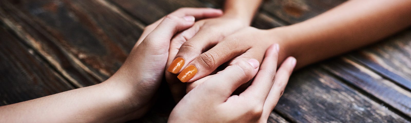 Closeup on two people’s hands, one person’s holding the others’.